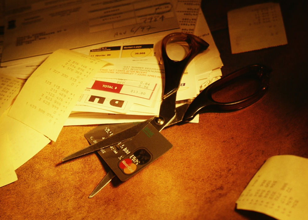 Scissors Cutting Credit Card, Surrounded in Piles of Bills