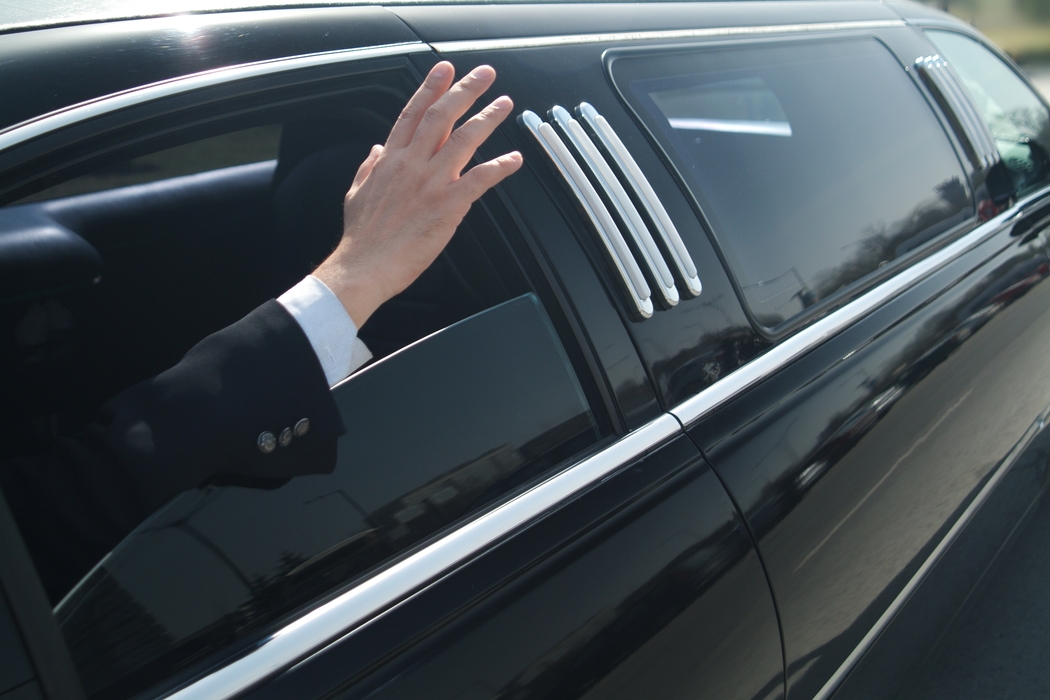 Businessman Waving From His Limousine