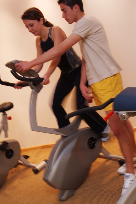 Personal Trainer and Woman on Stationary Bike