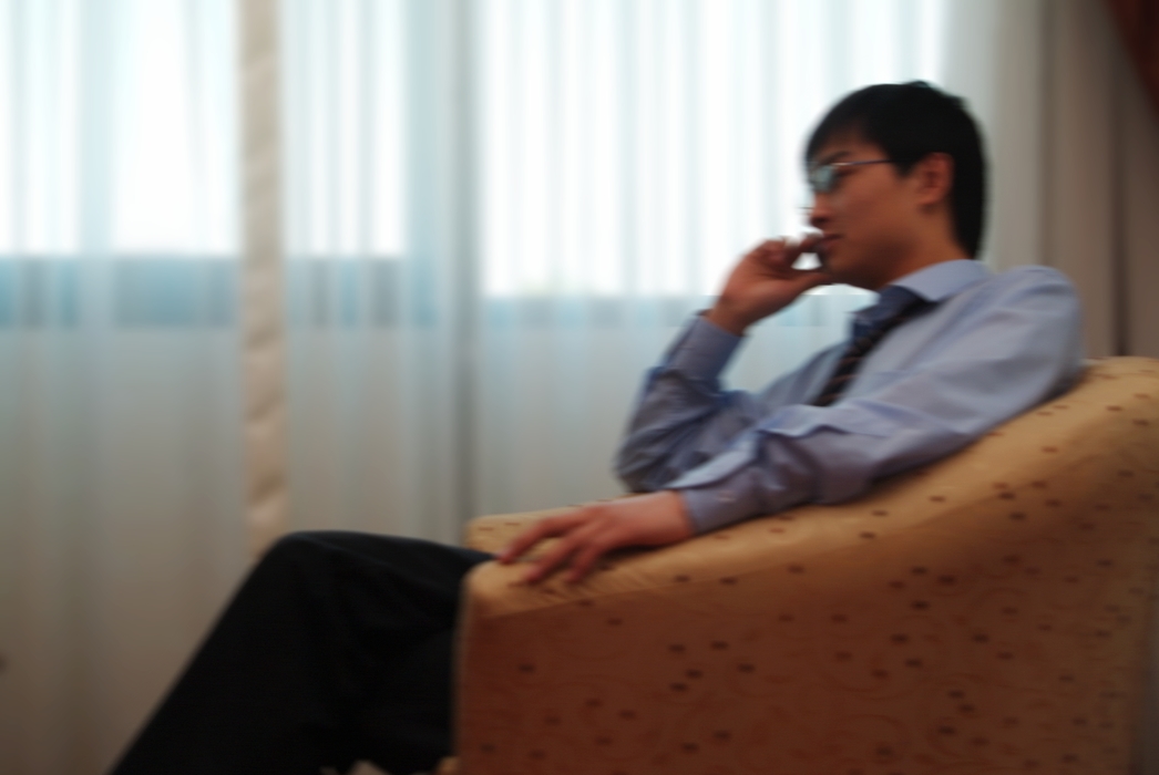 Man Sitting in a Chair Talking on Phone