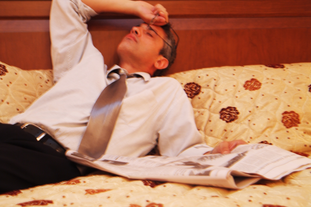 Businessman Reading Newspaper in Bed