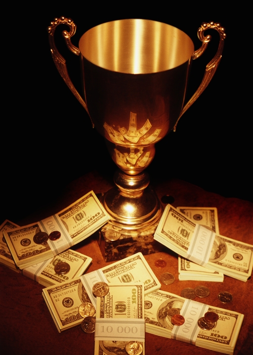 Trophy Surrounded with Stacks of Bills and Coins