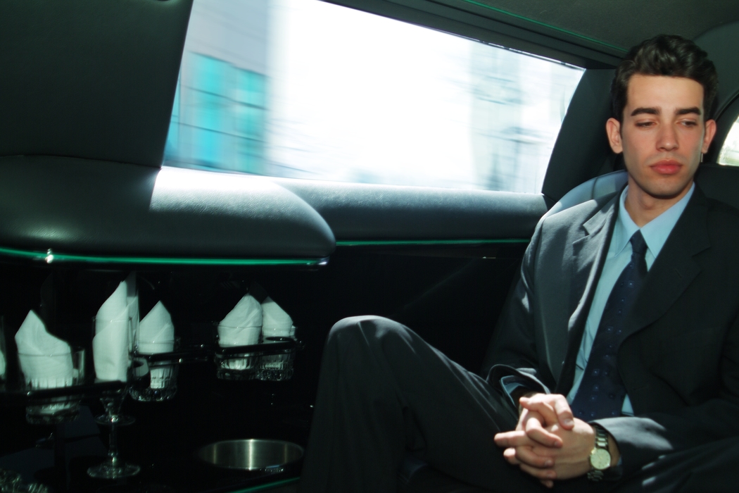 Businessman Traveling in a Limousine
