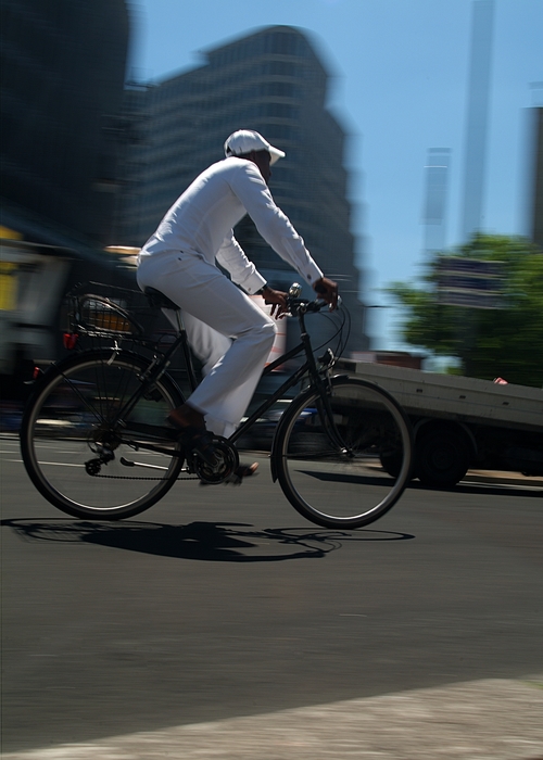 Cyclist Cycling to Work in City Traffic