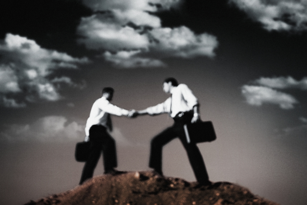 Businessmen Shaking Hands on Top of The Hill