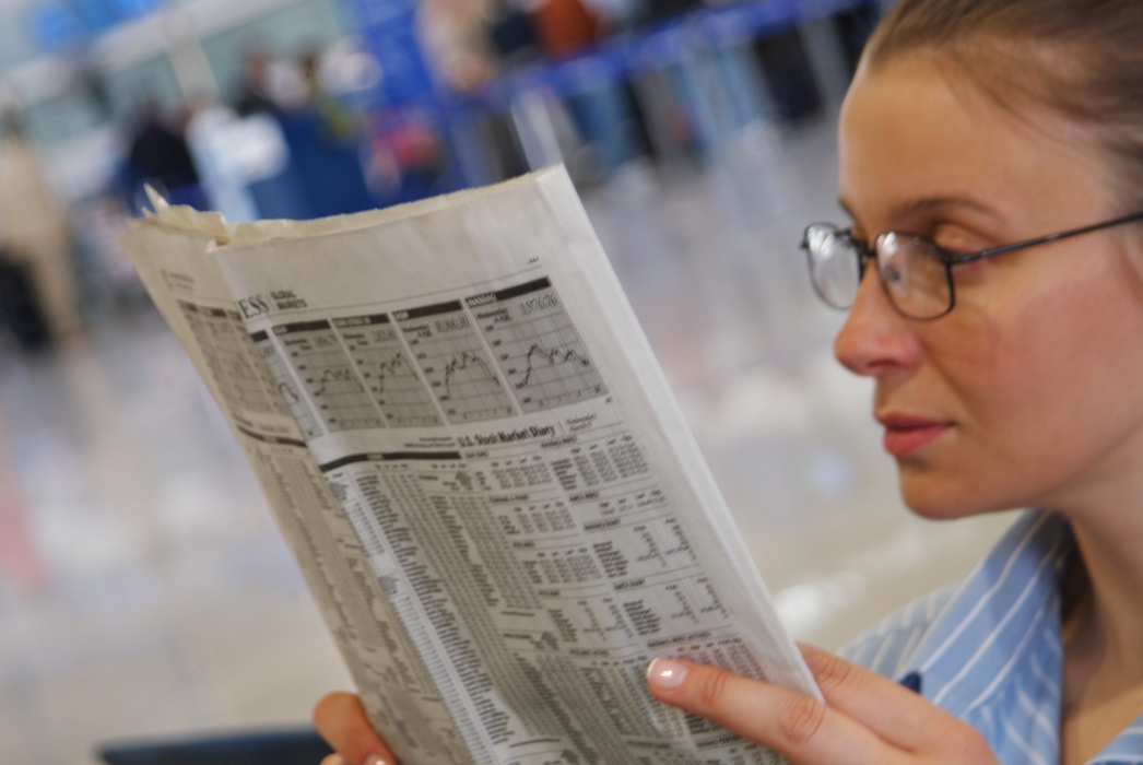 Woman Reading Newspaper in Terminal