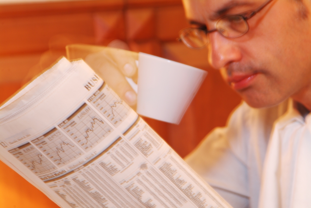 Businessman Having Coffee and Reading Newspaper