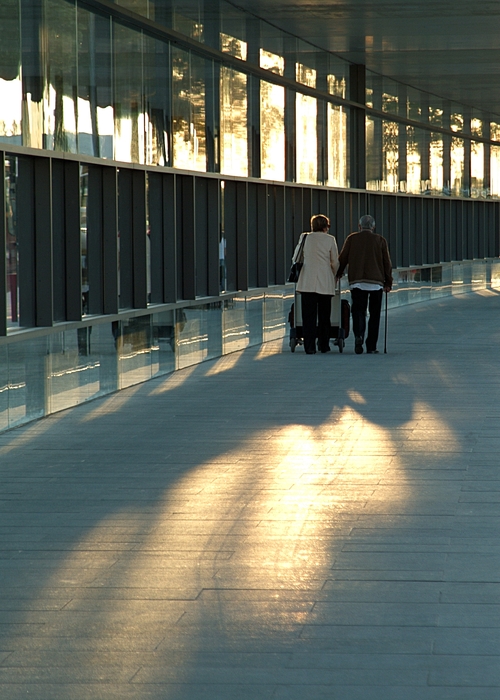 Elderly Couple Walking with Luggage Cart