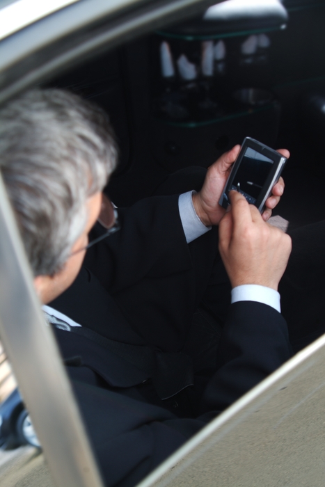 Man Working with His PDA in His Limousine
