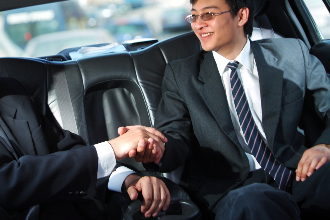 Businessmen Shaking Hands in a  Limousine