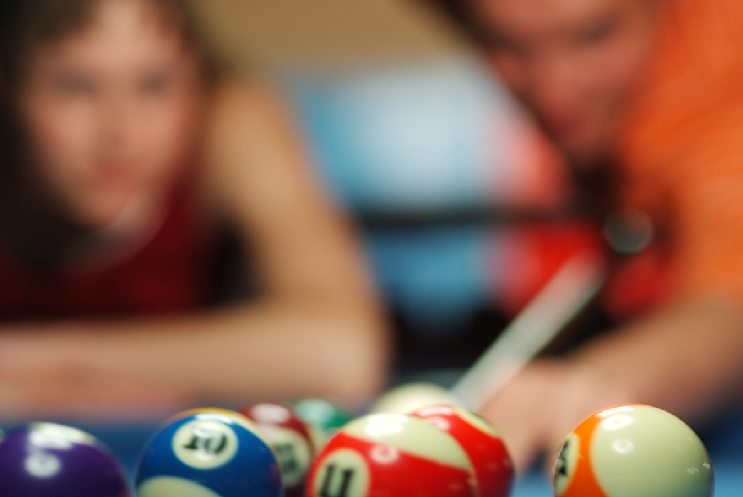 Pool Players Lining Up a Shot