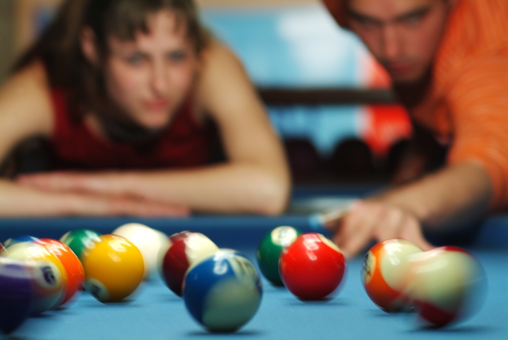 Pool Players Lining Up a Shot