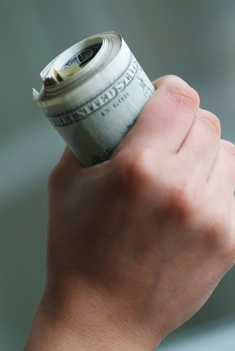 Hand Holding Fat Stack Roll of U.S. Currency 