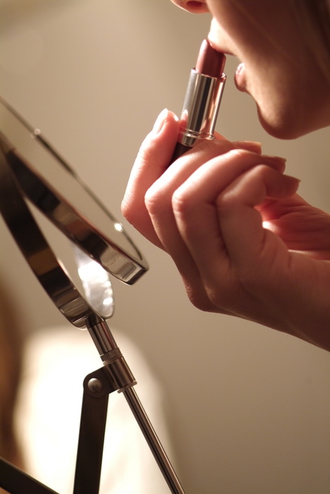 Woman Putting on Lipstick