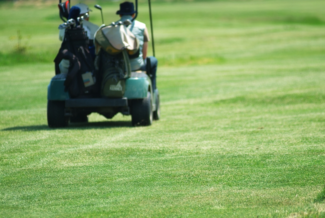 Golfers on The Fairway with a Power Cart