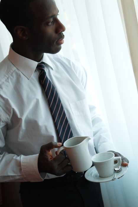 Businessman Having Coffee in Room