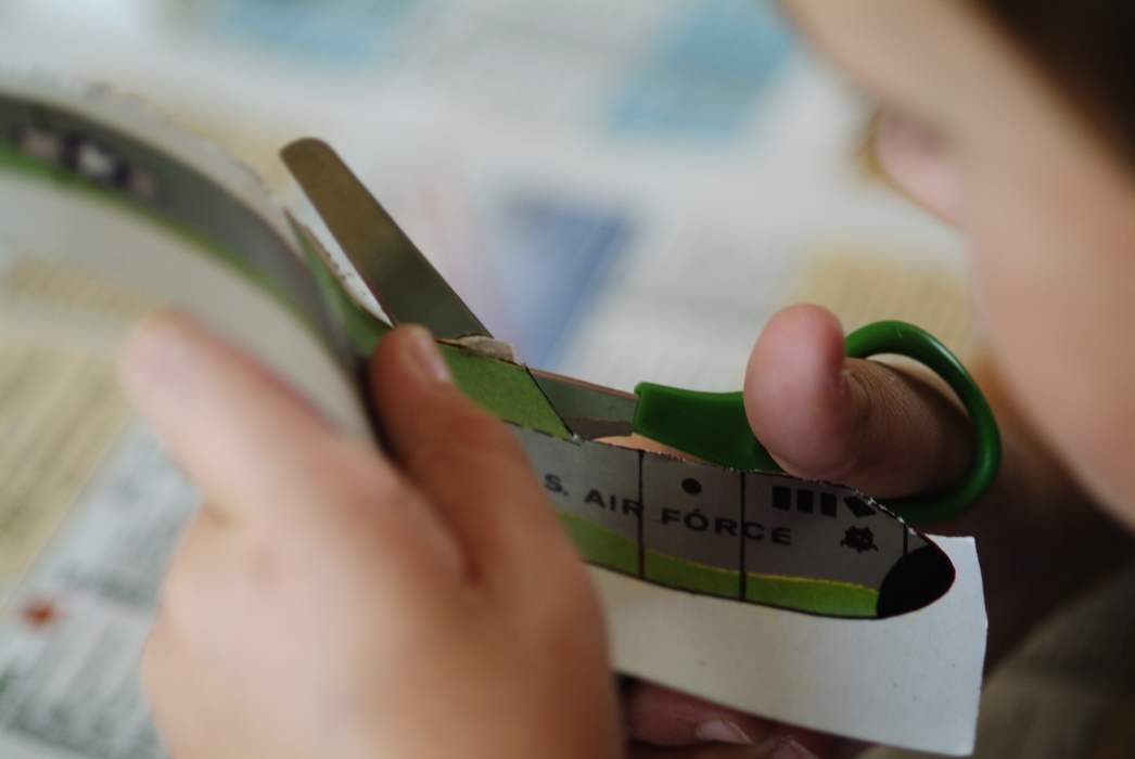 Child Cutting Paper with Scissors