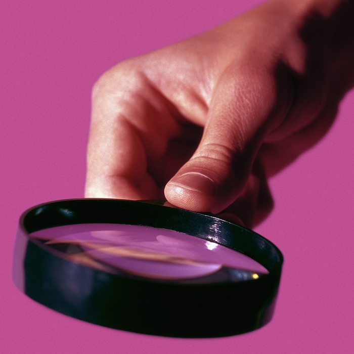 Hand Holding a Magnifying Glass