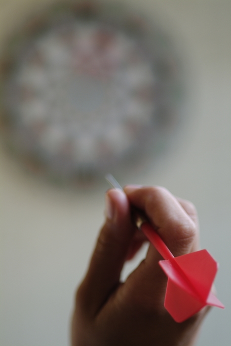 Hand Throwing Dart At a Dartboard