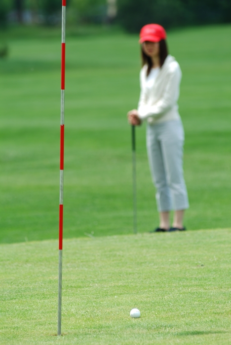 Female Golfer Watching Putt