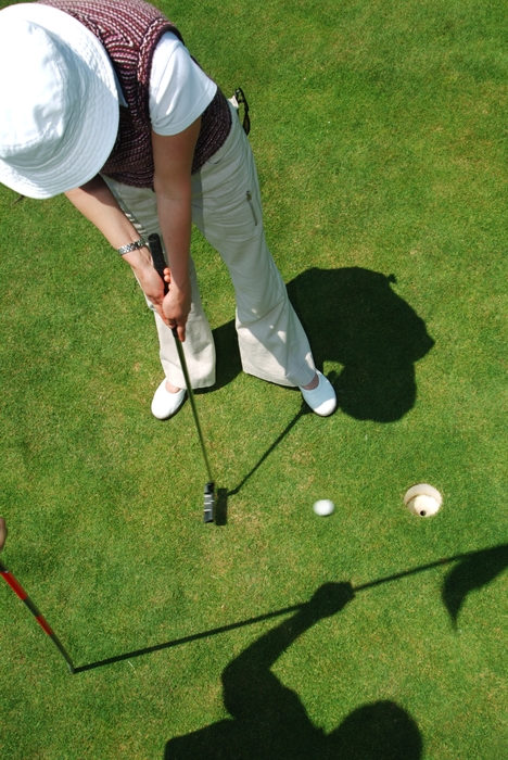 Female Golfer Making Putt