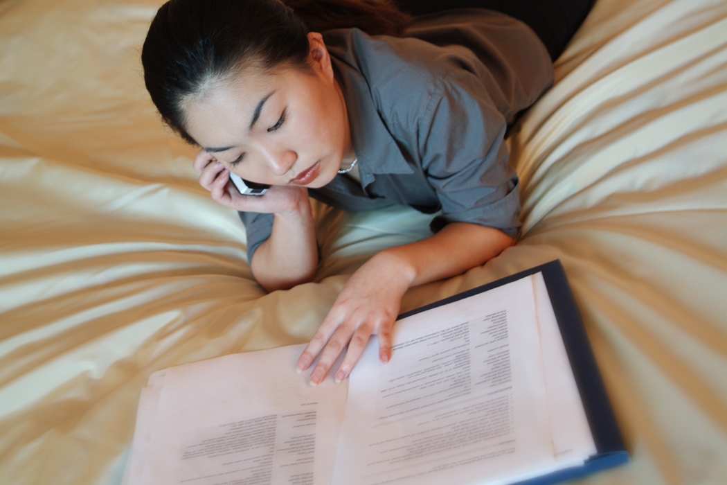 Woman Reviewing Documents While on Phone