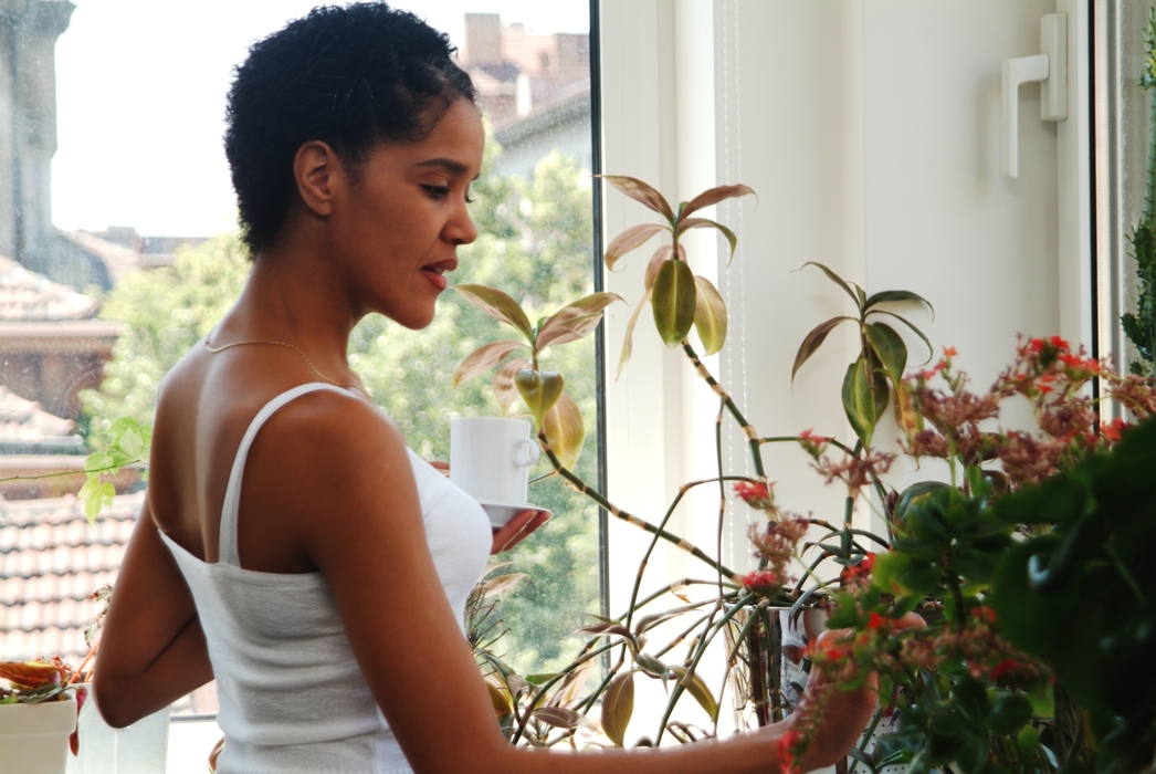 Woman Having Coffee and Tending to Flowers