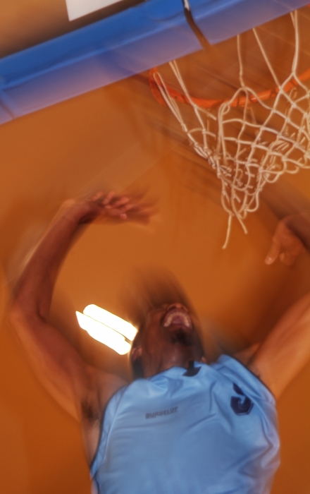 Basketball Player Jumps to the Net