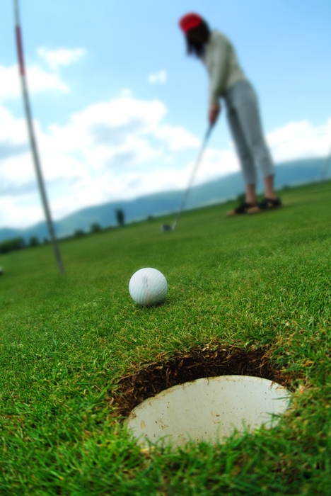 Female Golfer Watching Putt