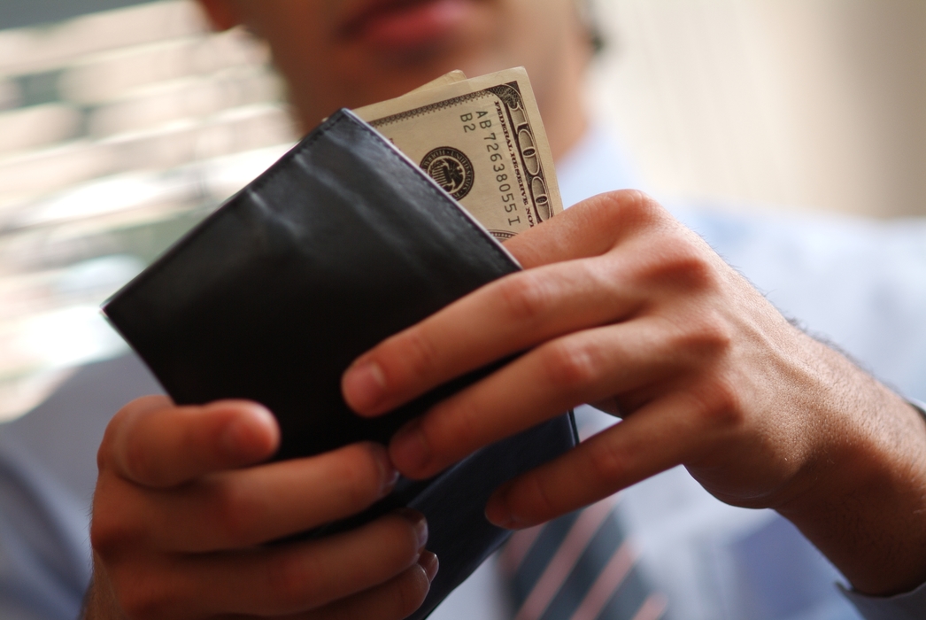 Man Putting Money in Wallet