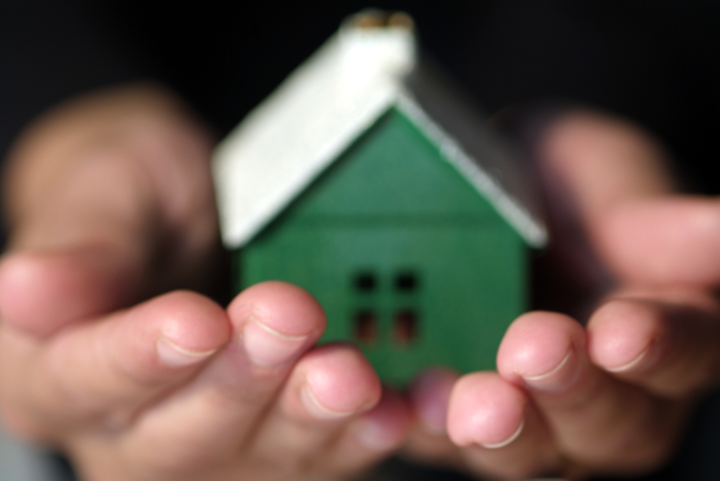 Hands Holding a Family Home