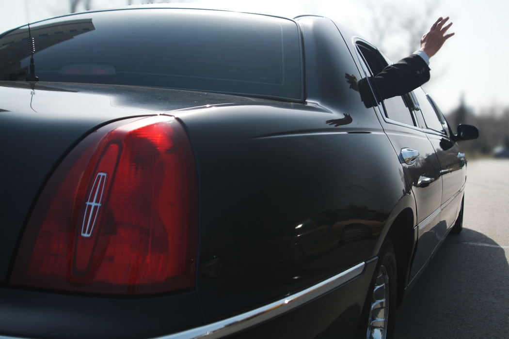 Businessman Waving From His Limousine