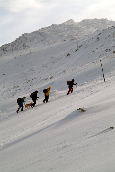 Hikers Climb Through Snow on Steep Mountain Terrain