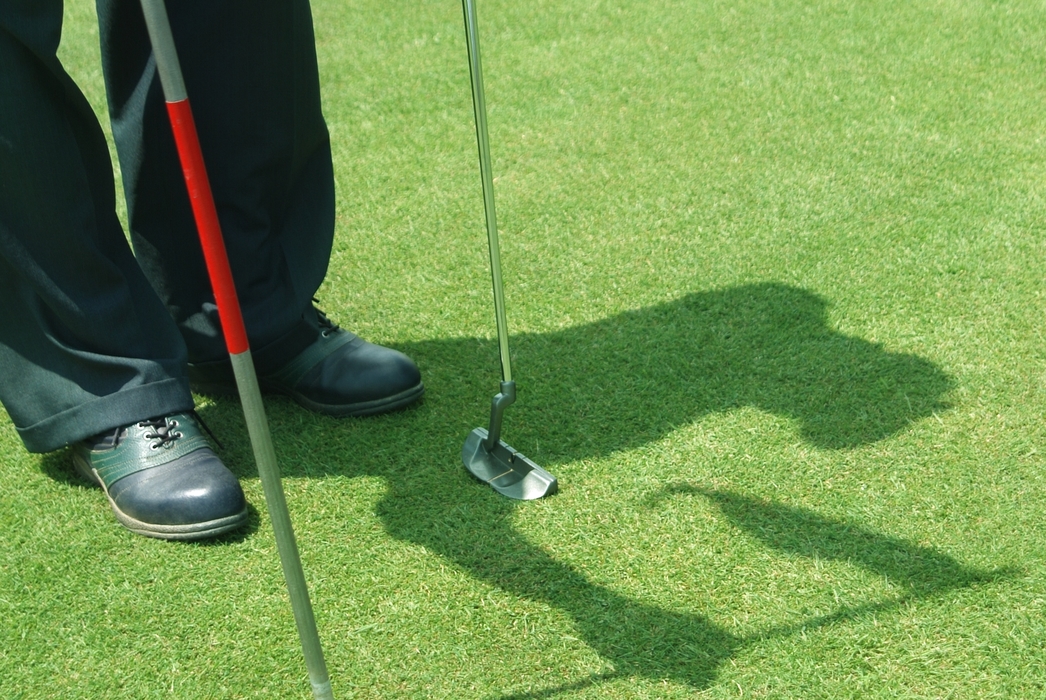 Golfer Replacing Flag Stick