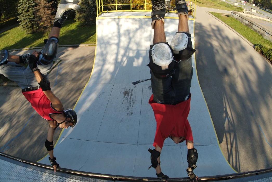 In-Line Skaters Rollerblading a Half-Pipe Handstand