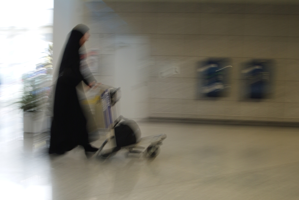 Woman Walking with Luggage Cart