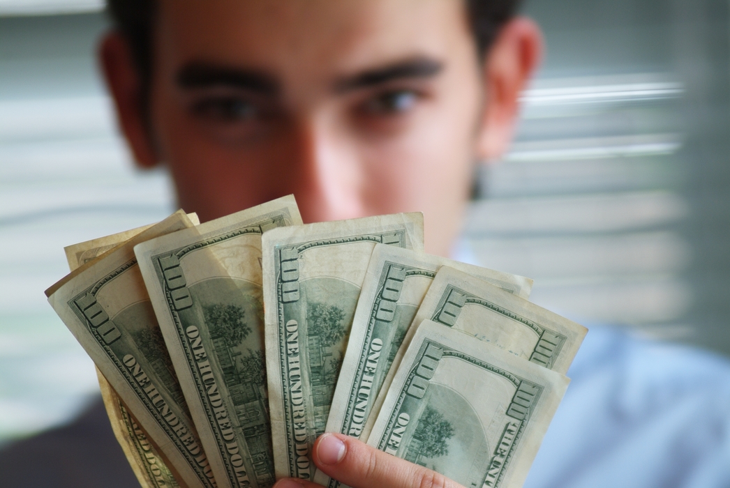 Man Holding U.S. One Hundred Dollar Money Bills