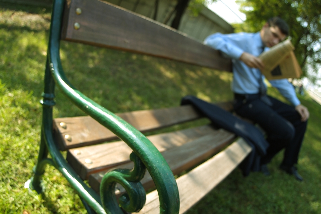 Man Reading the Newspaper on a Park Bench