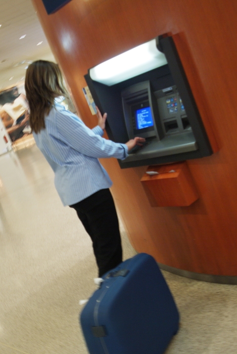 Woman At Bank Machine in Airport Terminal