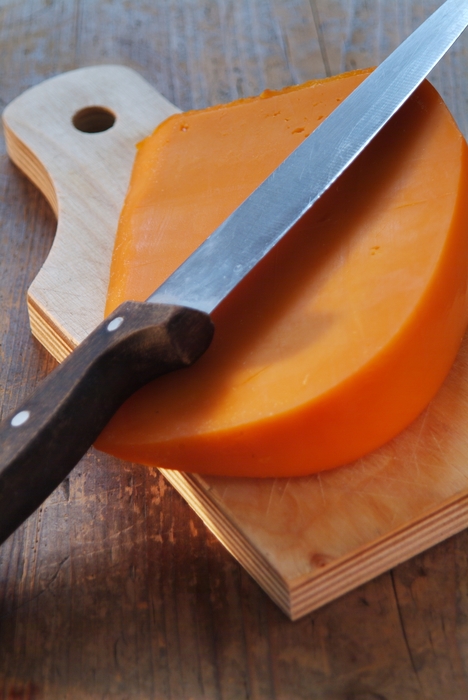Fresh Cheddar Cheese on Cutting Board with Knife