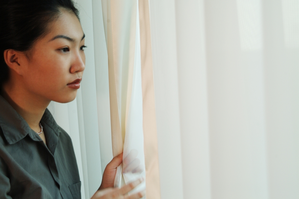 Woman Looking Out of Hotel Room