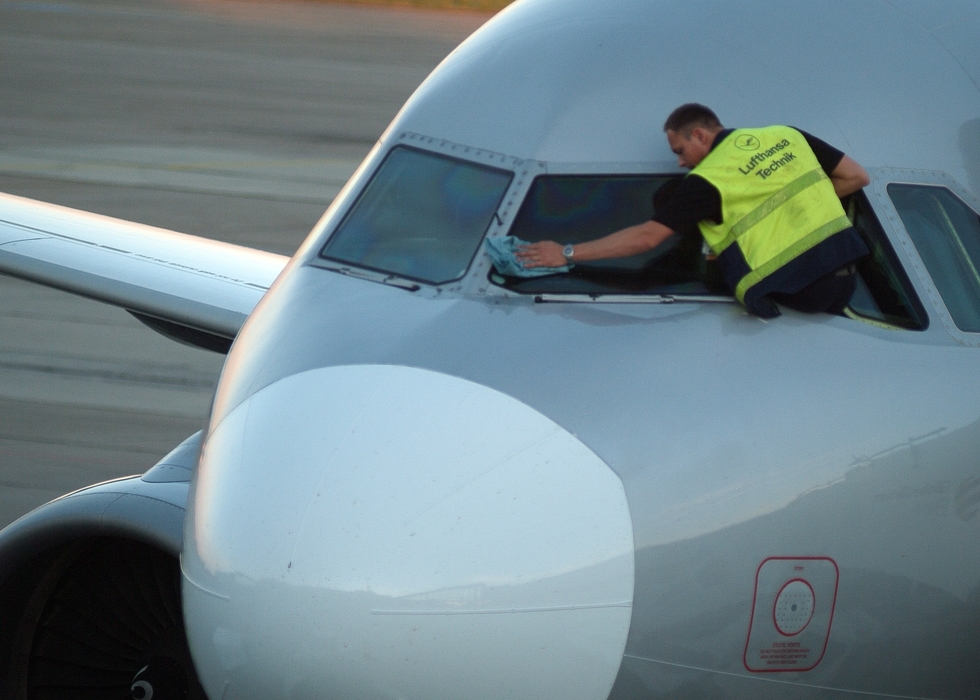 Aircraft Maintenance Worker Cleans Cockpit Window