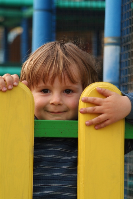 Boy Playing By a Fence