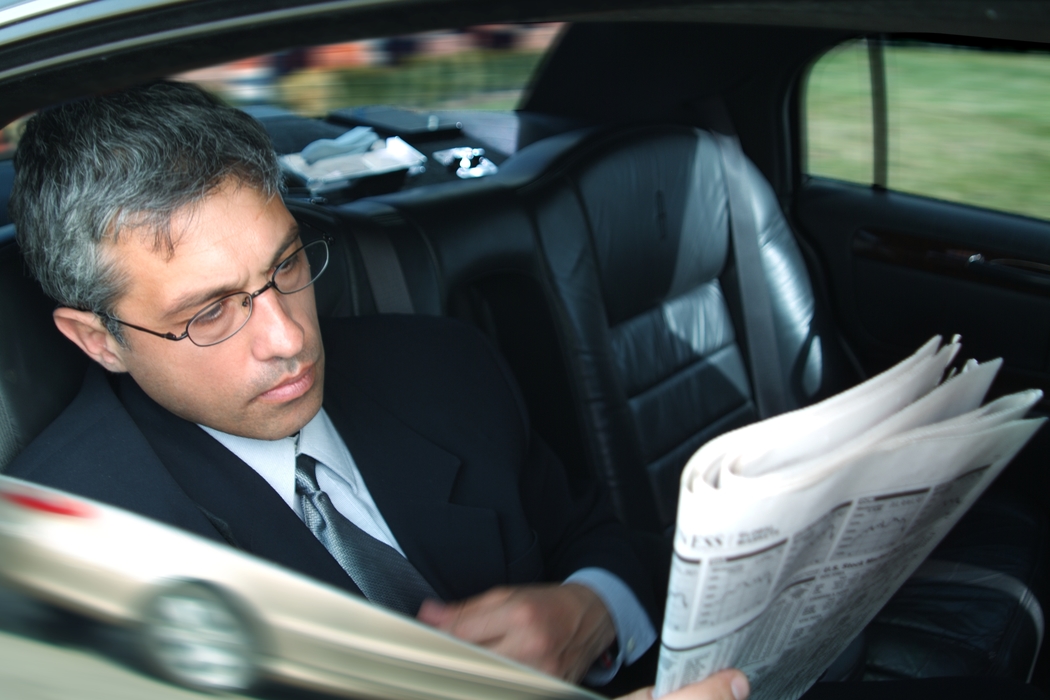 Businessmen Reading Paper in a  Limousine