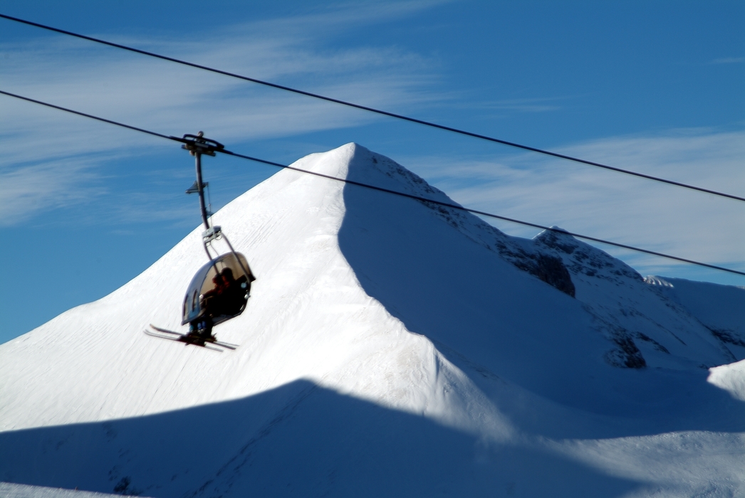 Gondola Ascends Mountain with Skiers