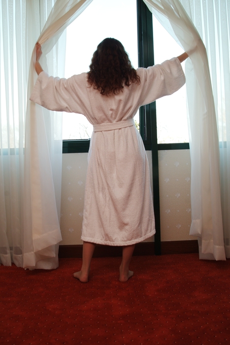 Woman Looking Out of Hotel Room