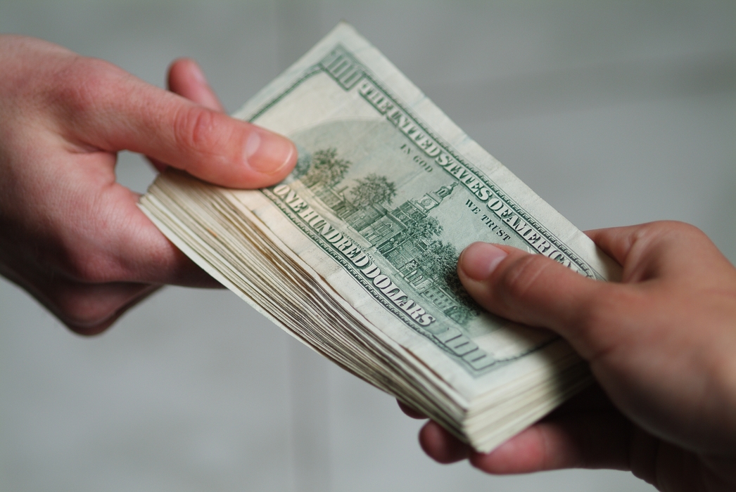 Hands Passing U.S. One Hundred Dollar Money Bills