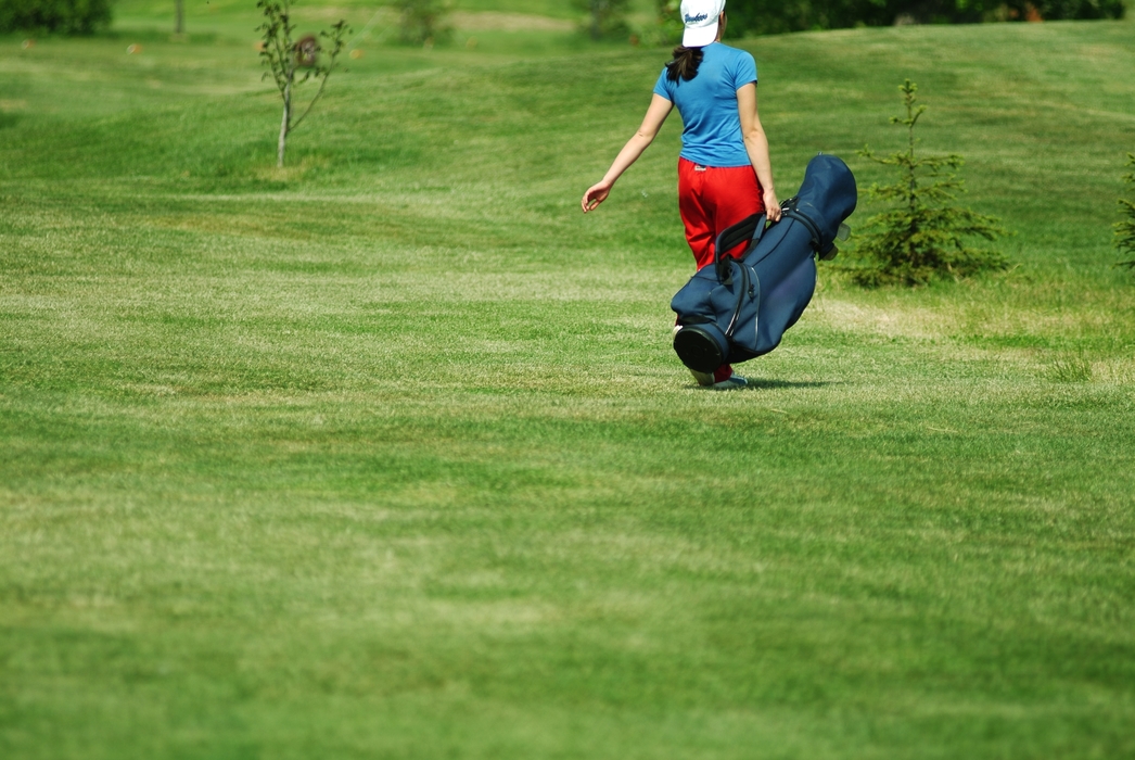 Golfer Walking with Her Golf Bag