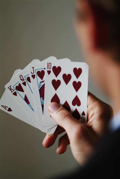 Hand Holding Playing Cards with Royal Flush