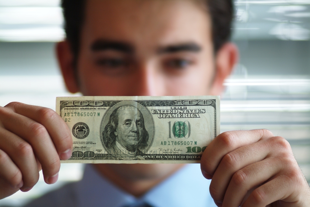 Man Holding U.S. One Hundred Dollar Money Bill